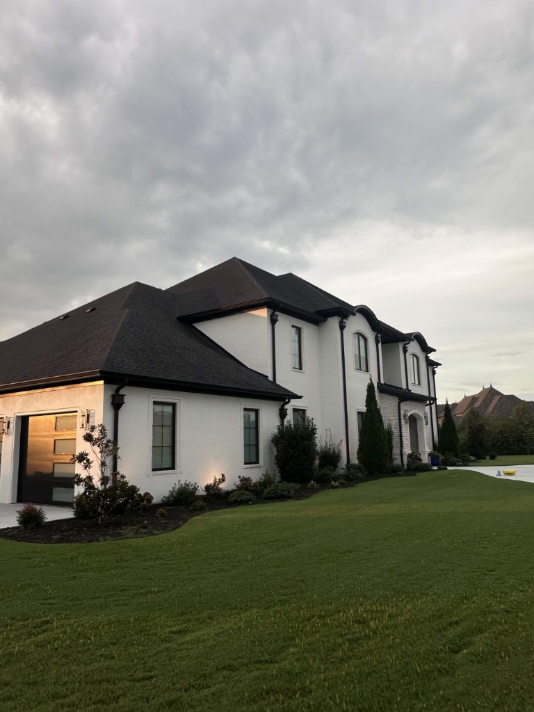 White stucco home with clean siding and lighting